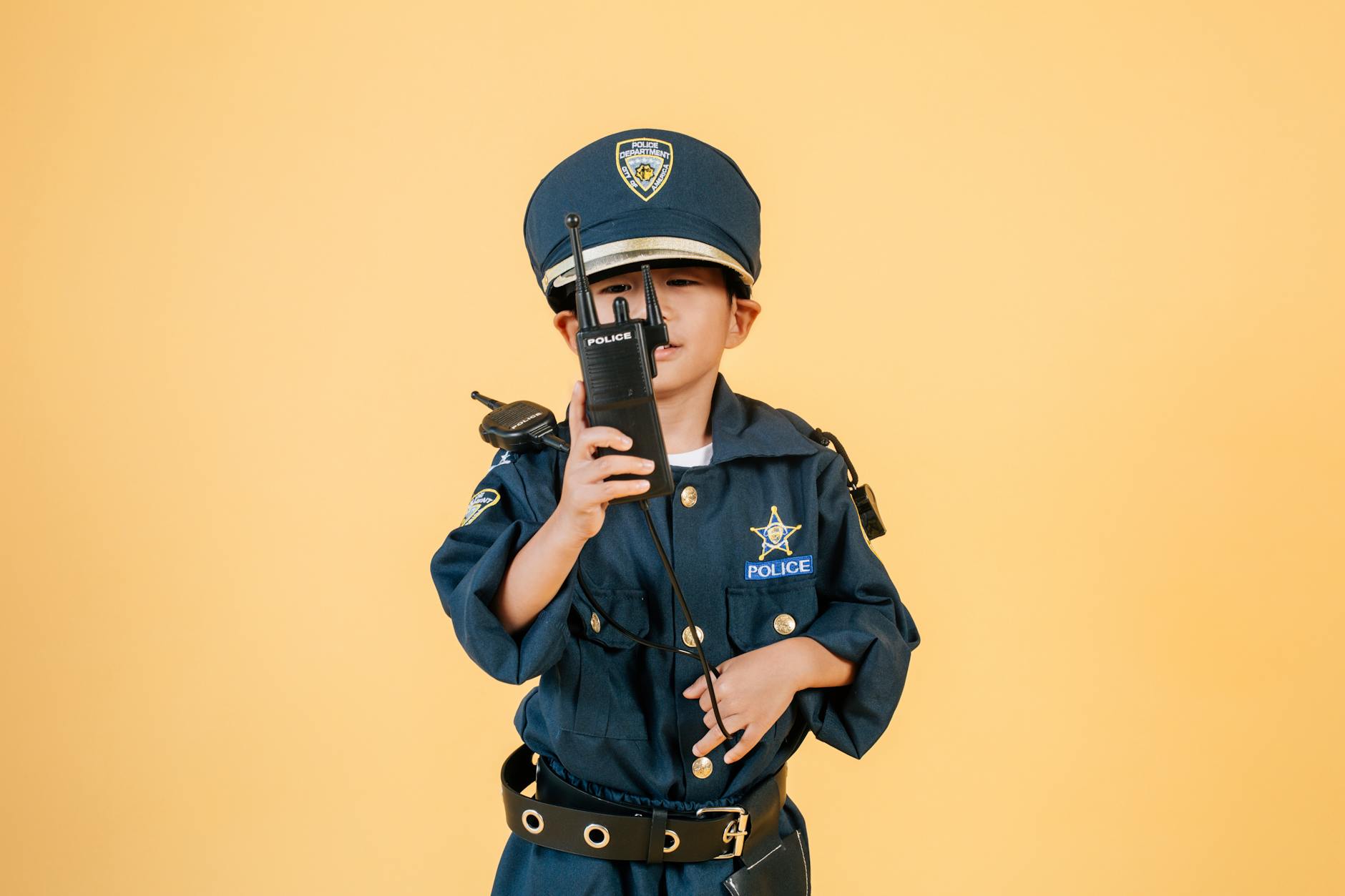 boy in police uniform against yellow background
